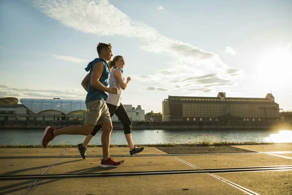 Young couple running by the riverside